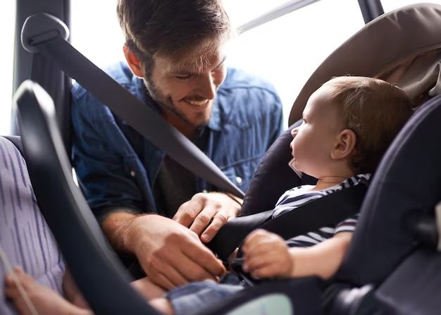 Father securing child in booster seat